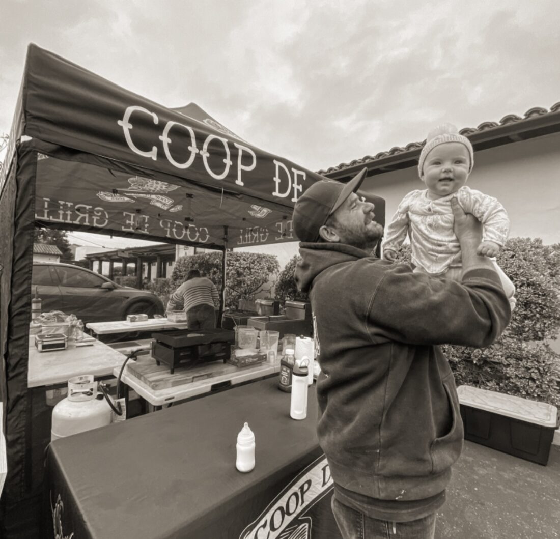 Cole holding his baby at the Coop de Grill booth