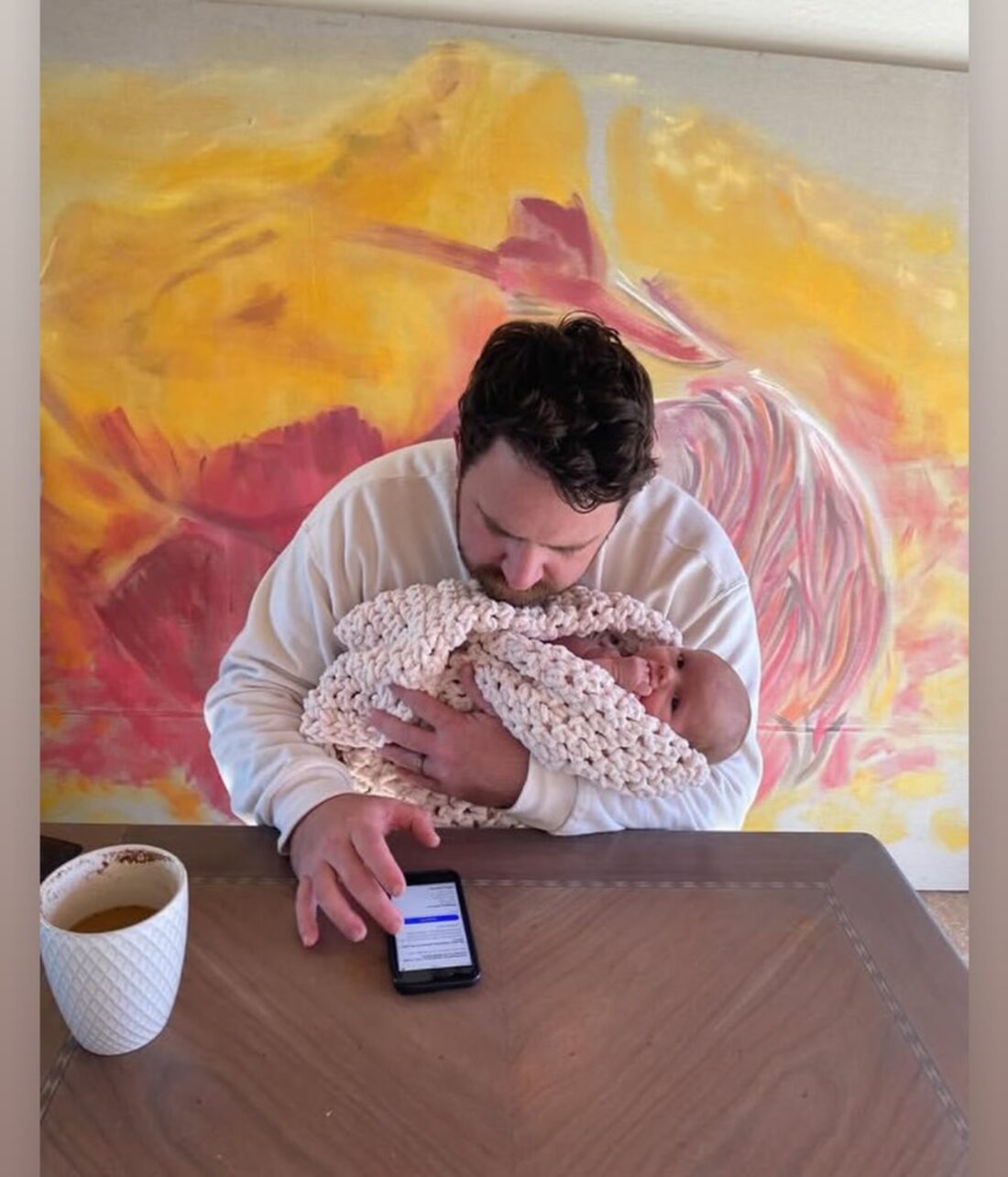 Cole holding his newborn while taking catering inquiries